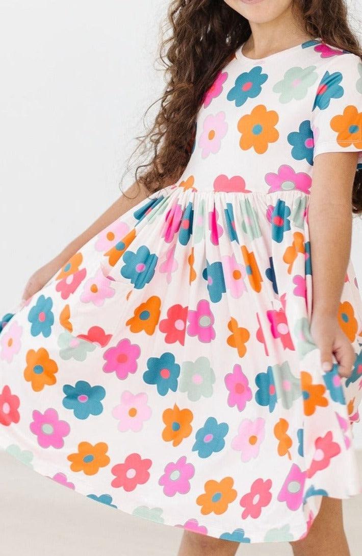 a girl wearing a dress with flowers on it