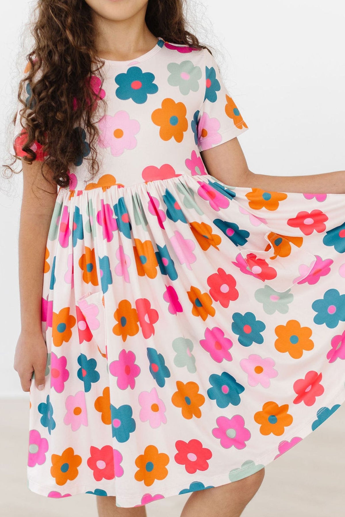 a girl wearing a dress with flowers on it