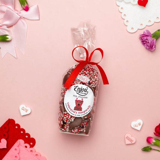 a bag of chocolate with a red ribbon and flowers