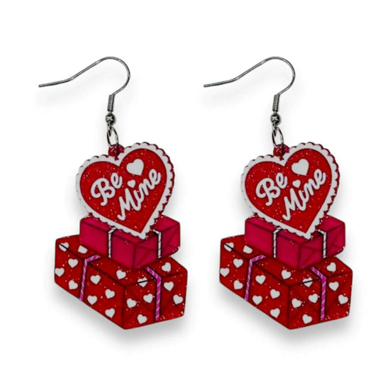 a pair of earrings with a heart shaped present