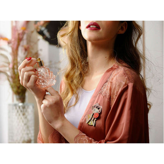 a woman holding a bottle of perfume