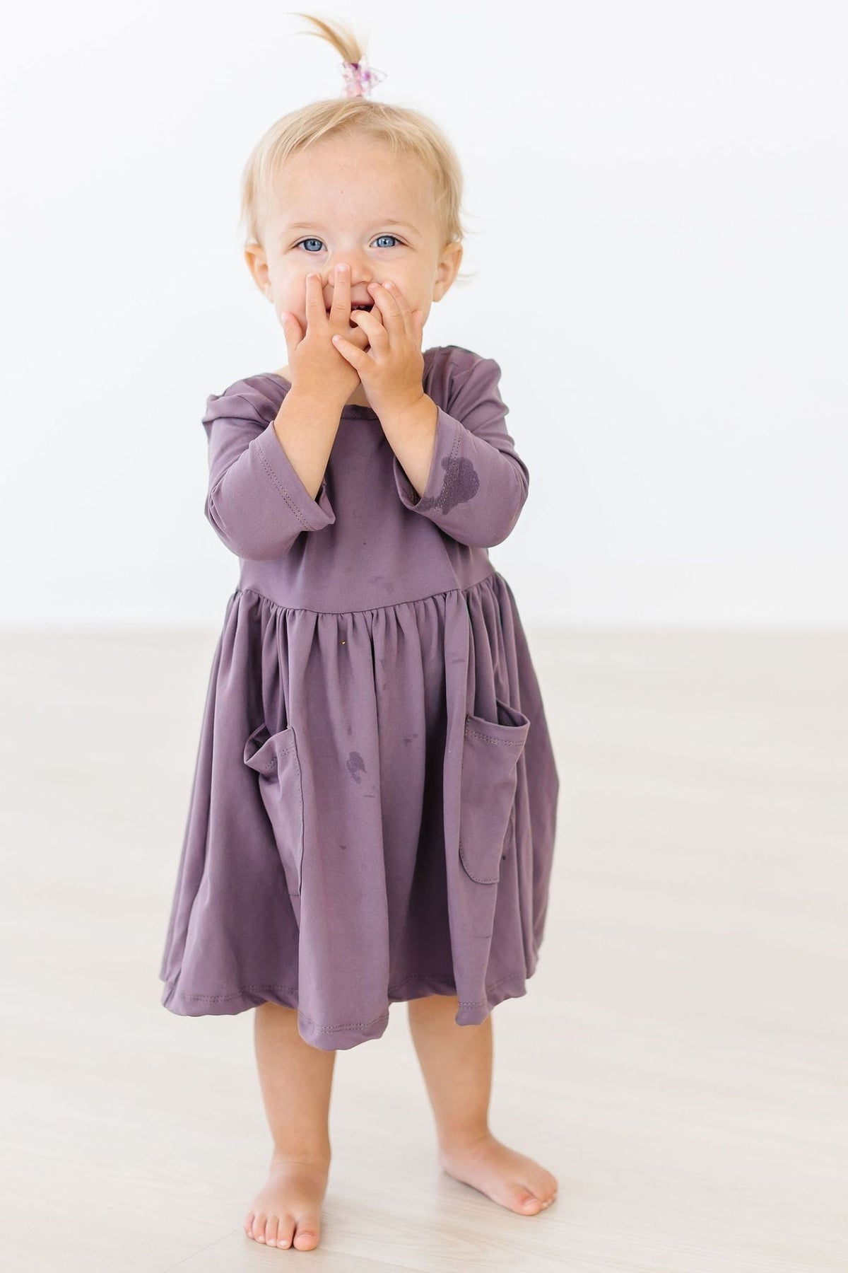 a child with her hands over her mouth