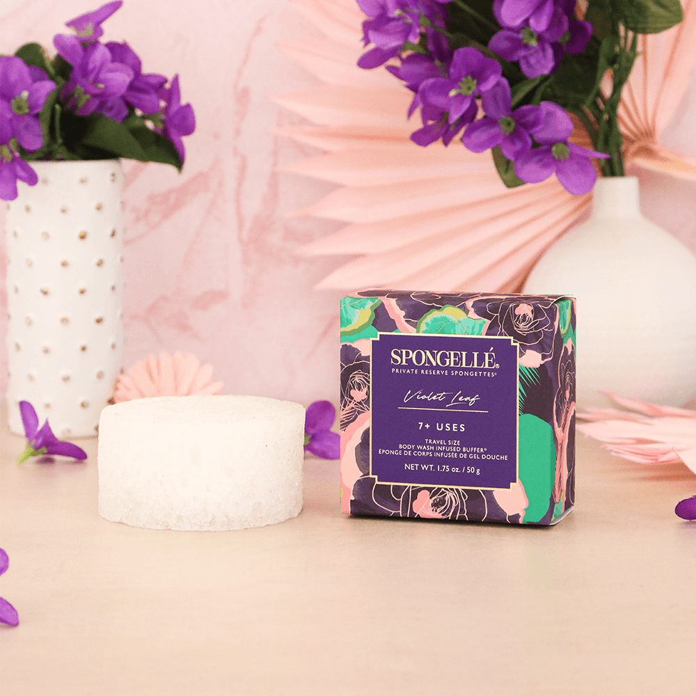 a box of soap next to a sponge and flowers