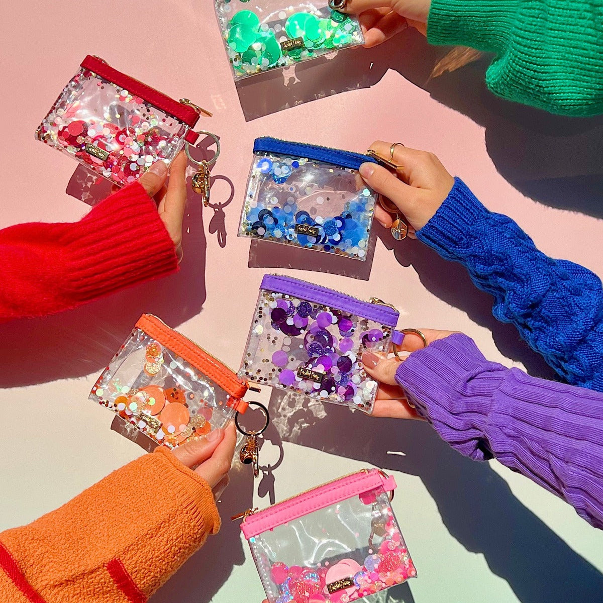 a group of hands holding small bags