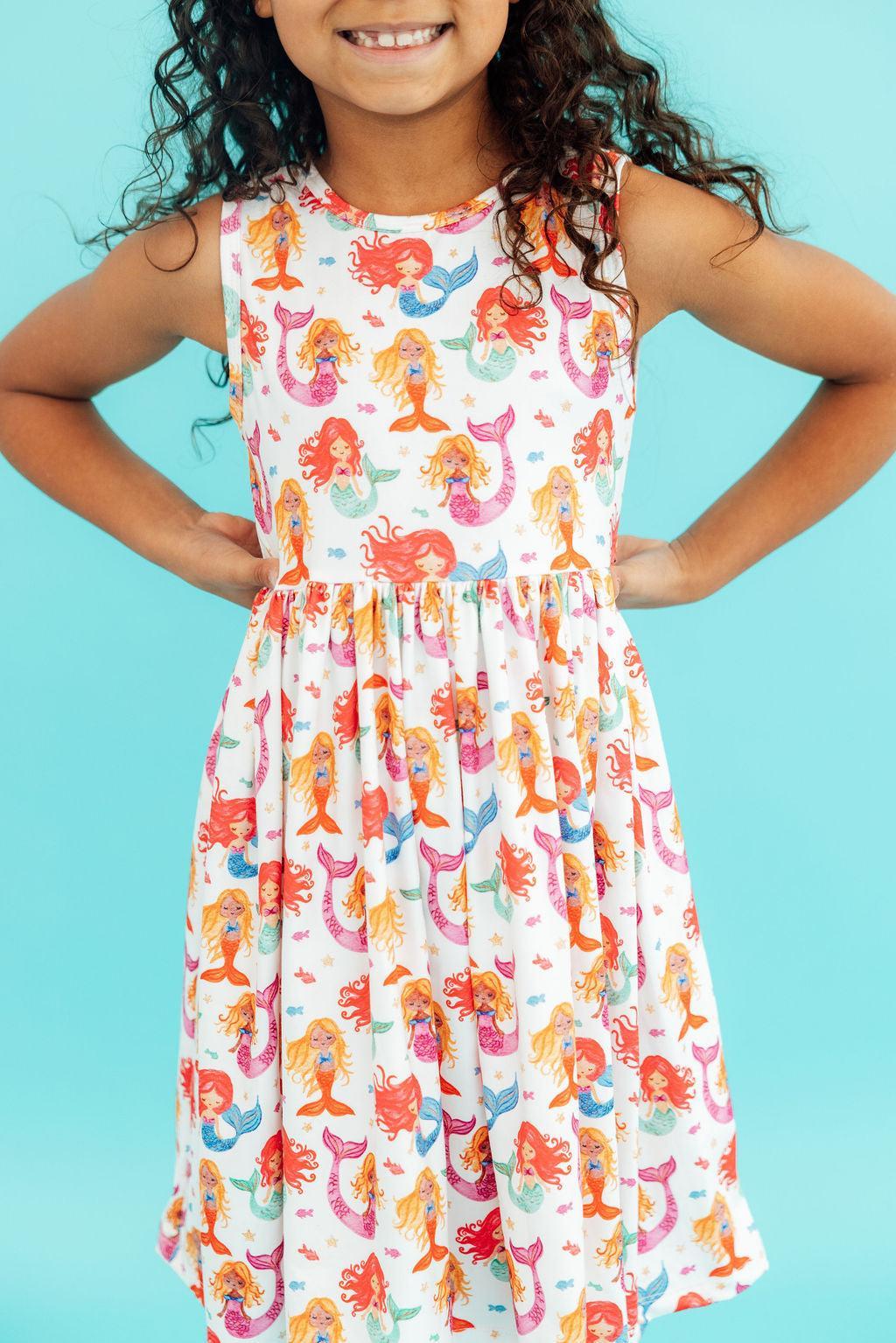 a girl in a dress with mermaids on her waist