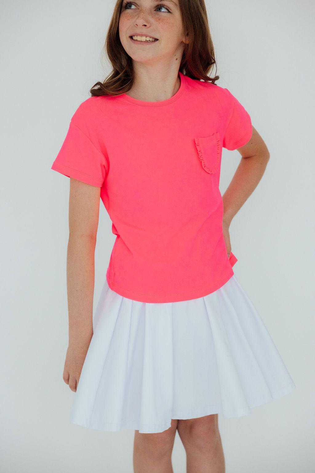 a girl in a pink shirt and white skirt