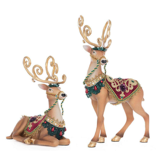 two reindeer figurines with gold and green decorations
