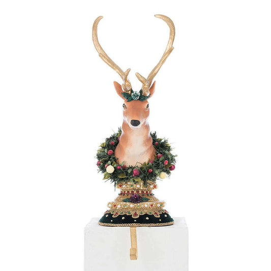 a statue of a deer with a dress and wreath