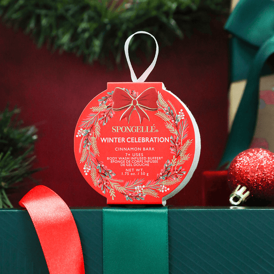 a red and green gift box with a ribbon and ornaments