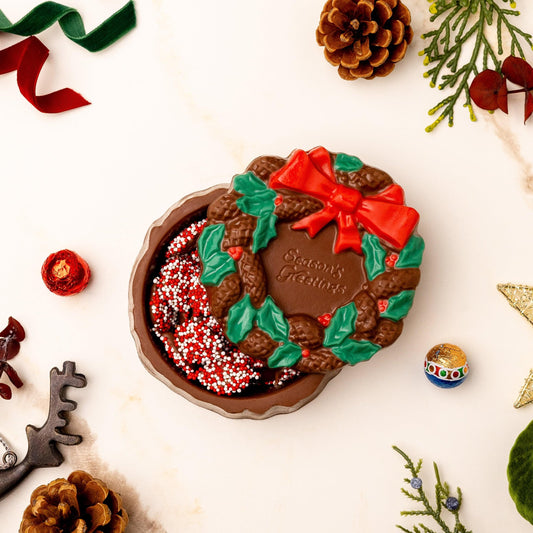a chocolate cookie in a bowl with a bow and sprinkles