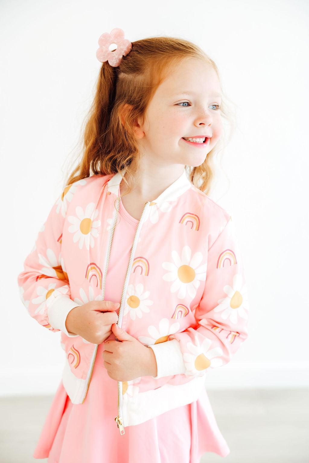 a girl smiling with a pink jacket
