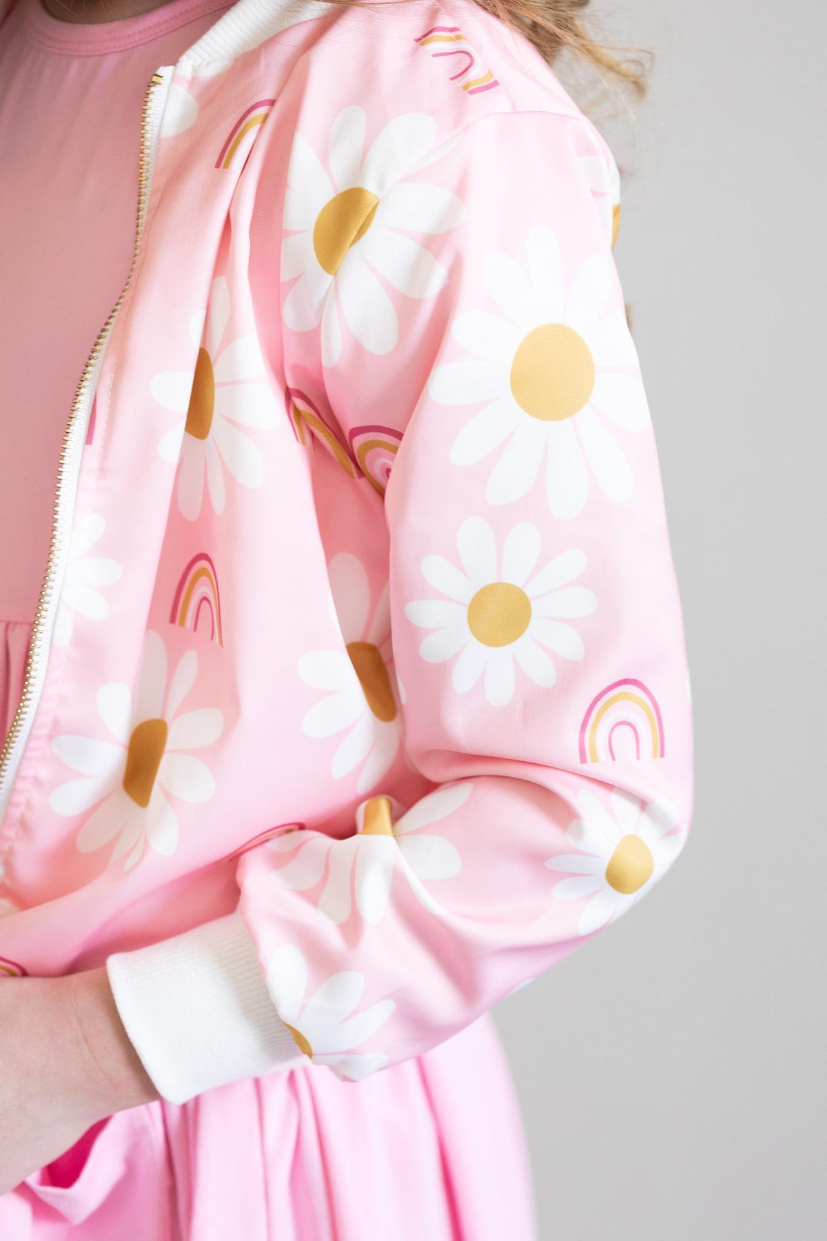 a person wearing a pink jacket with white flowers