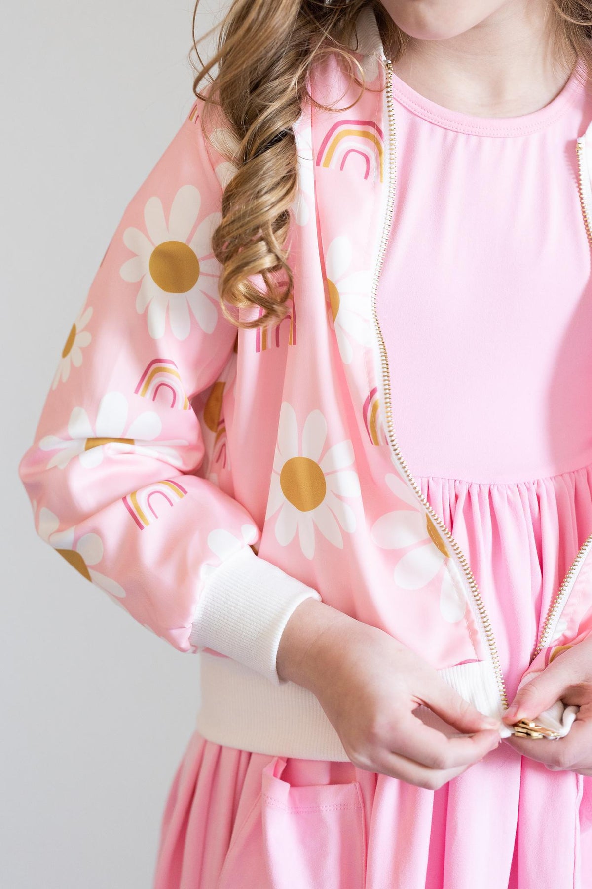 a girl wearing a pink jacket and pink skirt
