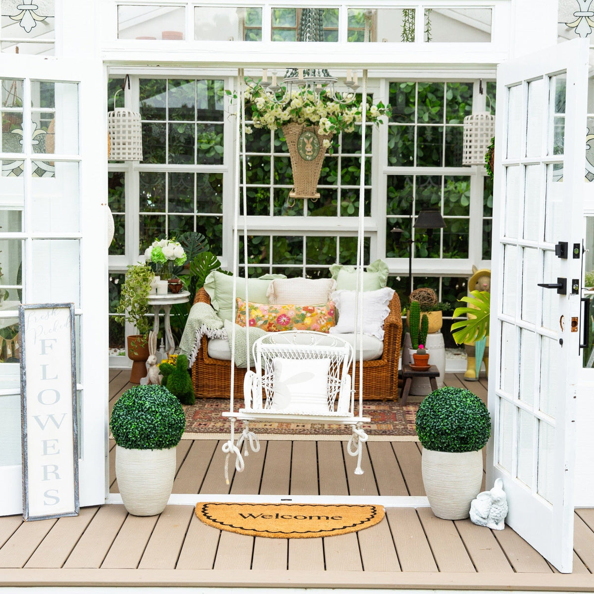 a porch with a swing and plants in pots