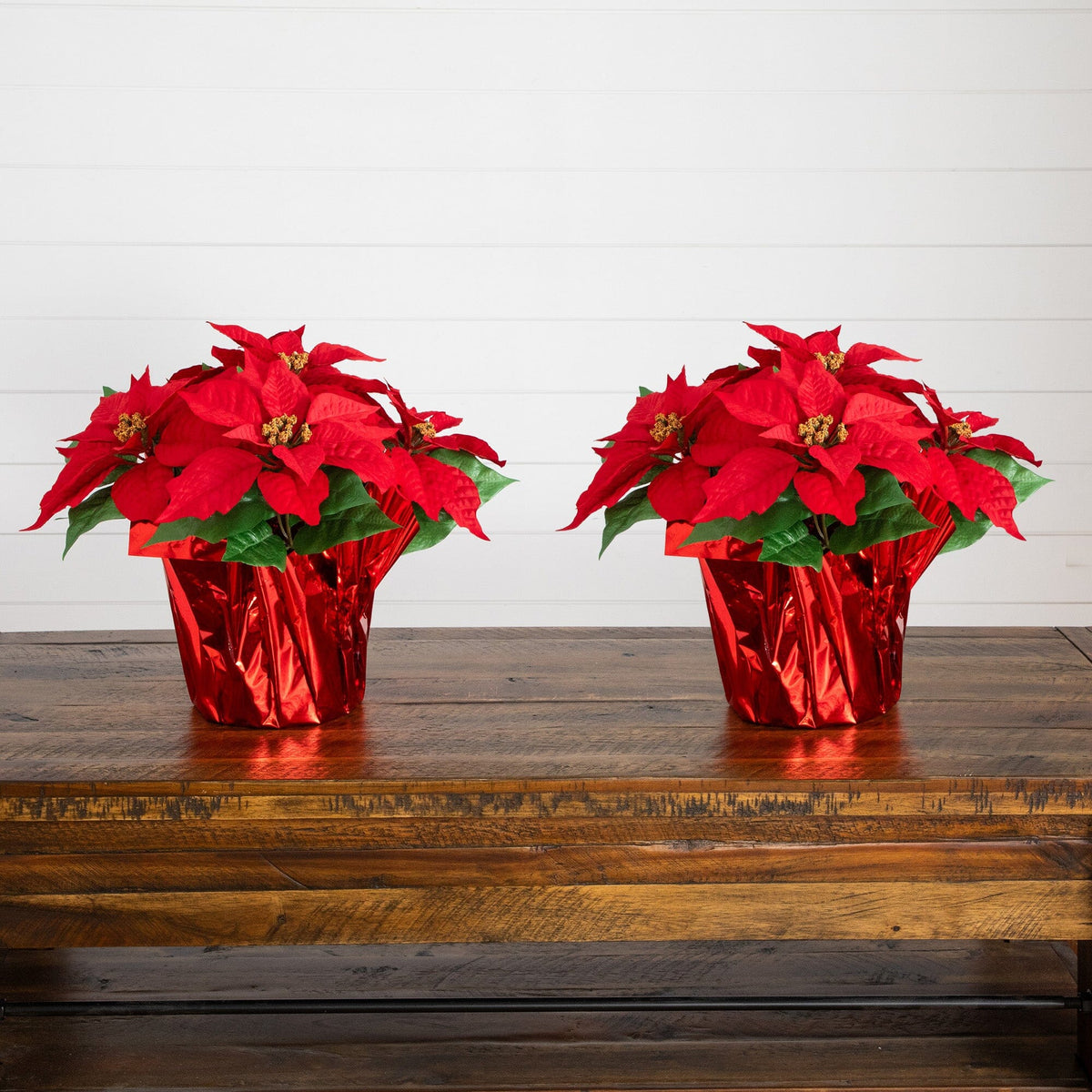 two red flowers in foil on a wooden table