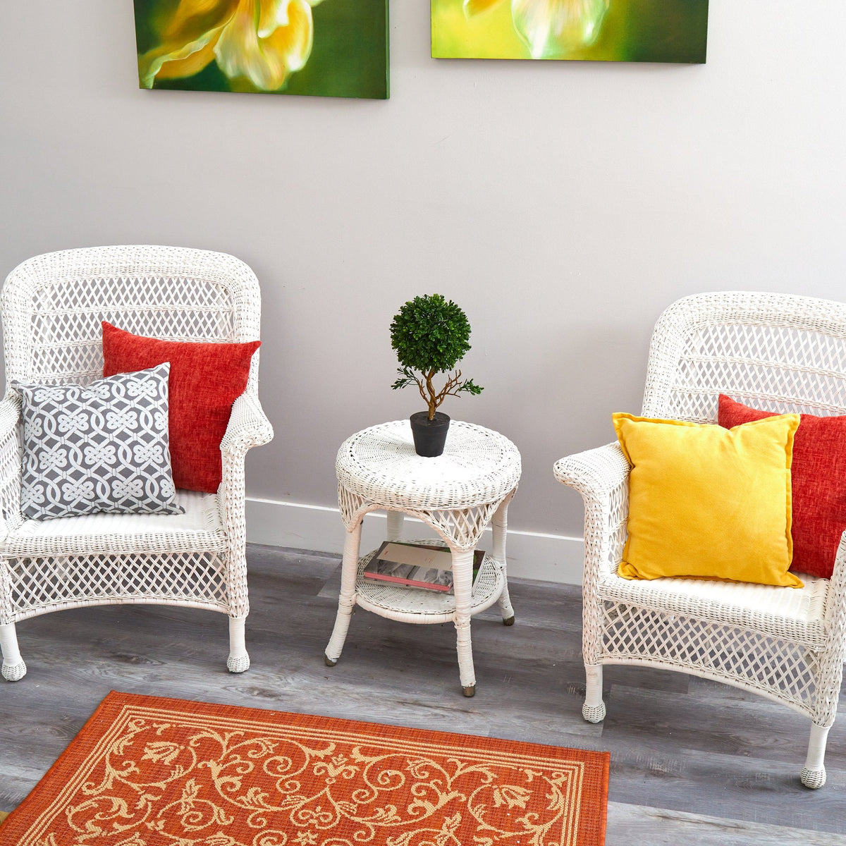 a white wicker chairs and a small table with a small plant