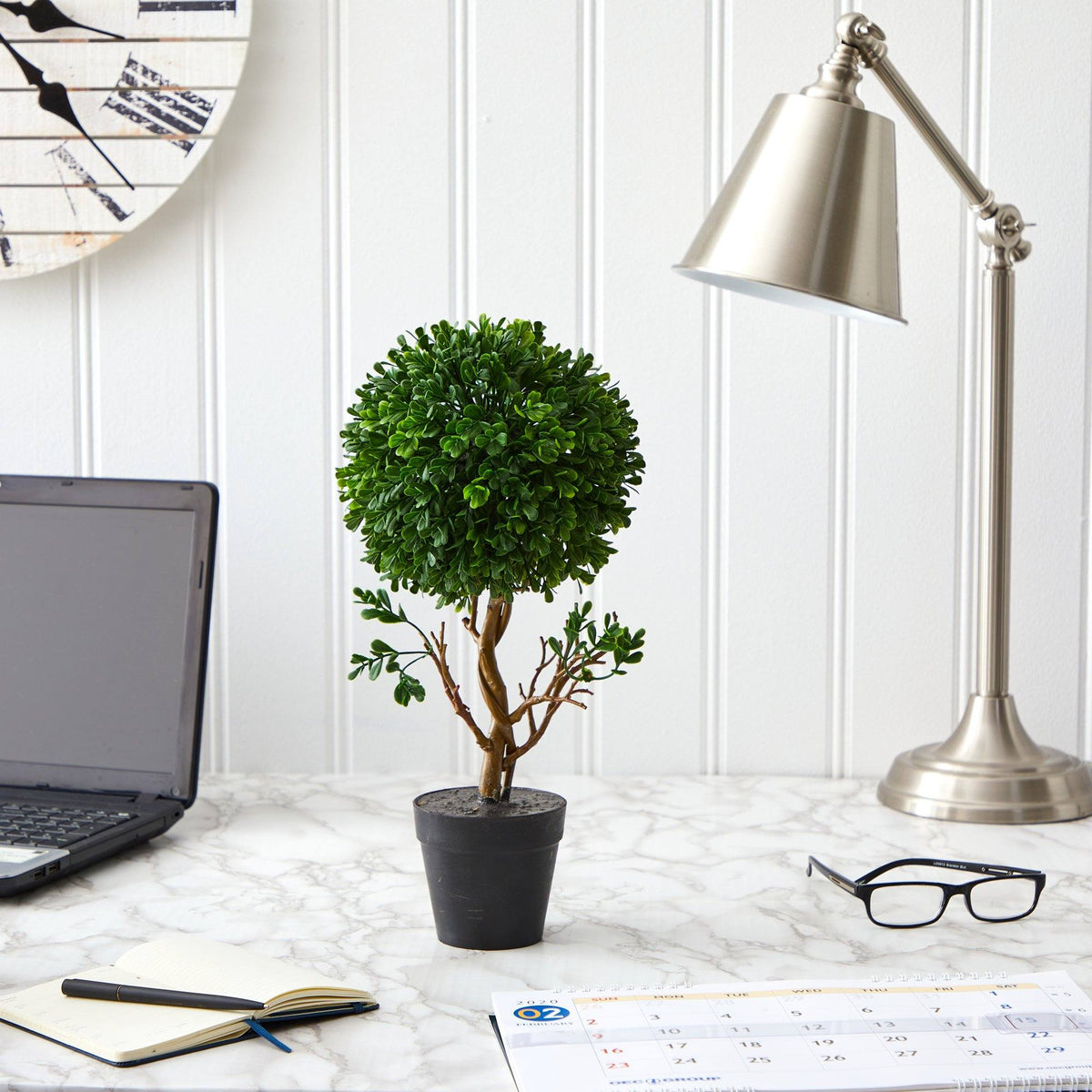 a plant in a pot on a marble desk