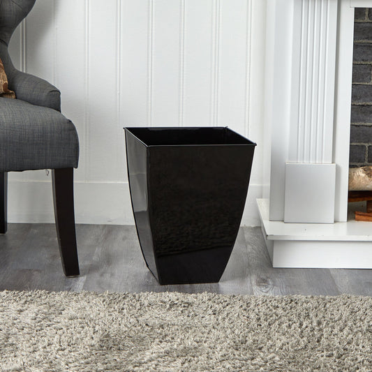 a black vase next to a fireplace
