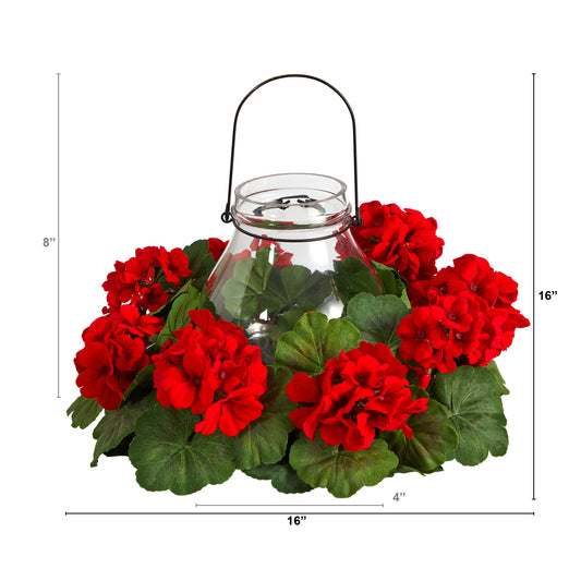 a glass vase with red flowers and green leaves