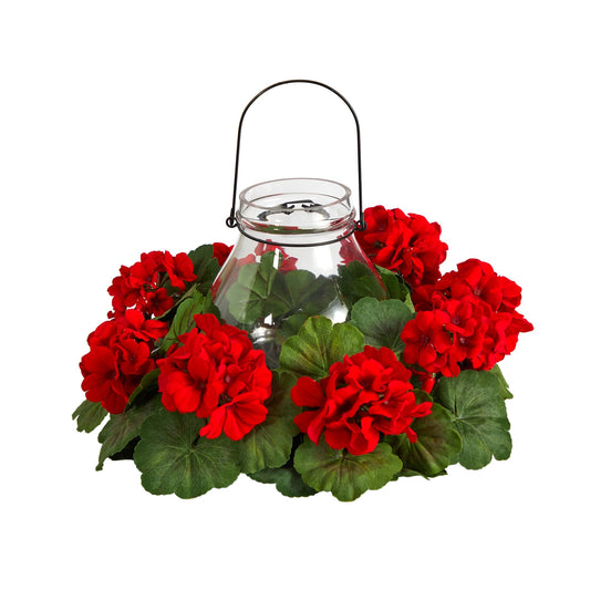 a glass jar with red flowers and green leaves