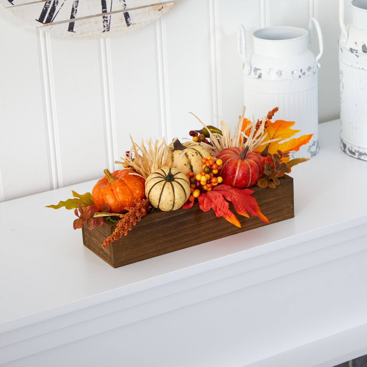a wooden box with small pumpkins and leaves