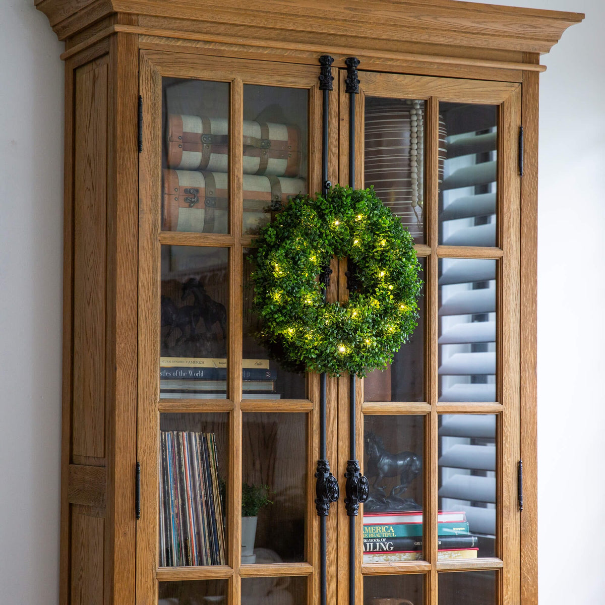 a wood cabinet with a wreath on top