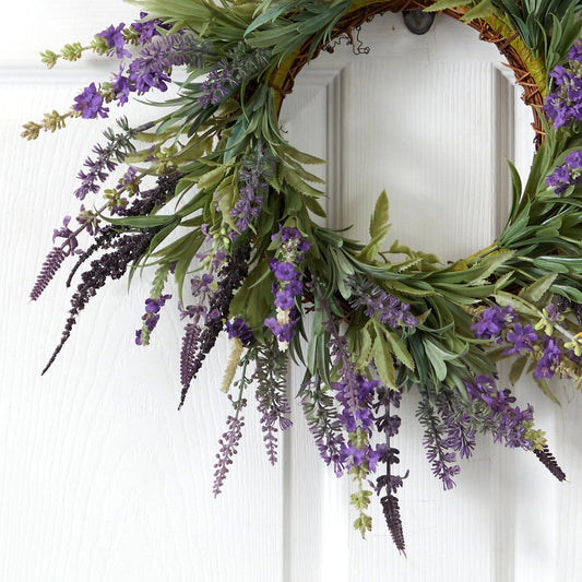 a wreath with purple flowers on a white door