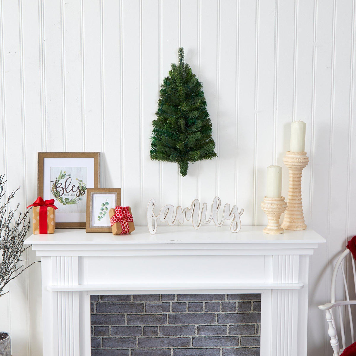 a fireplace with a small tree and pictures on the wall