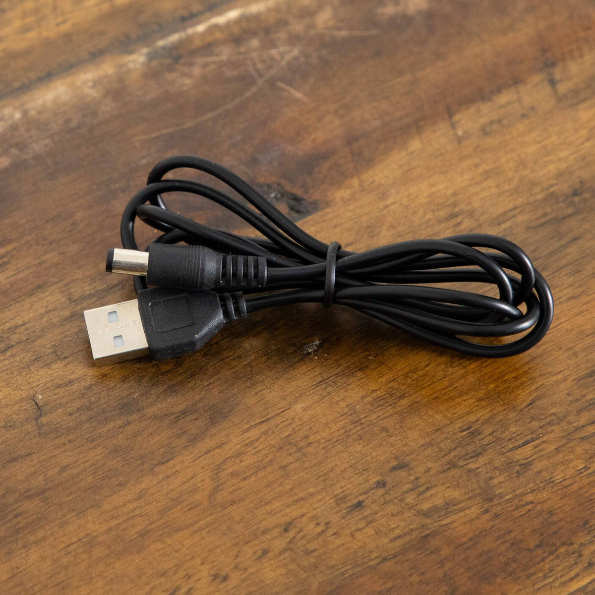 a black cable on a wood surface