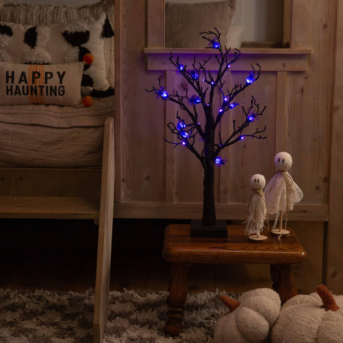 a small table with a tree and two dolls on it