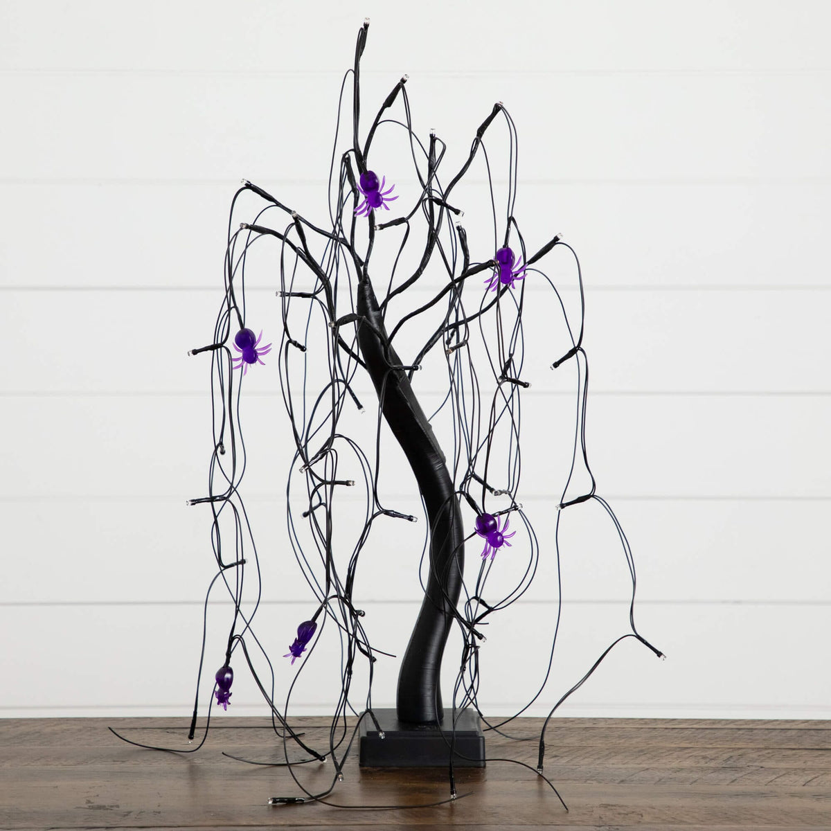 a black tree with purple spiders on it