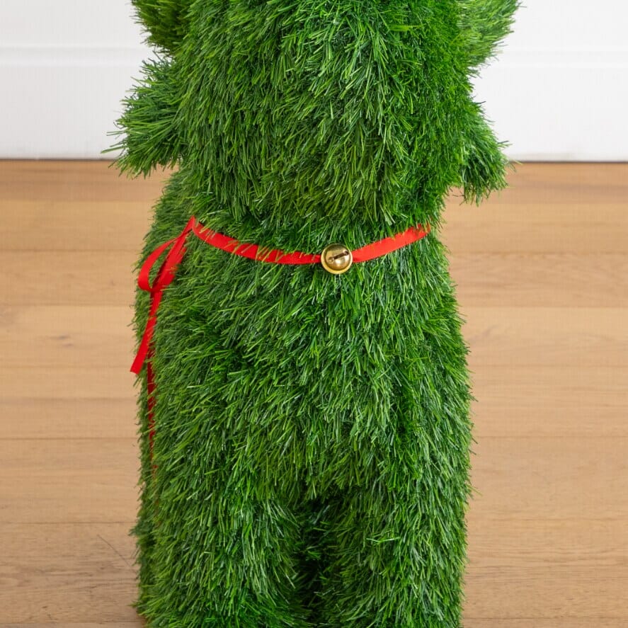 a green grass dog with red ribbon