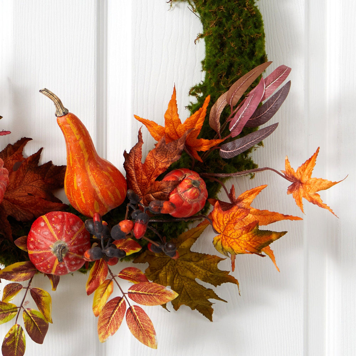 a wreath with leaves and pumpkins
