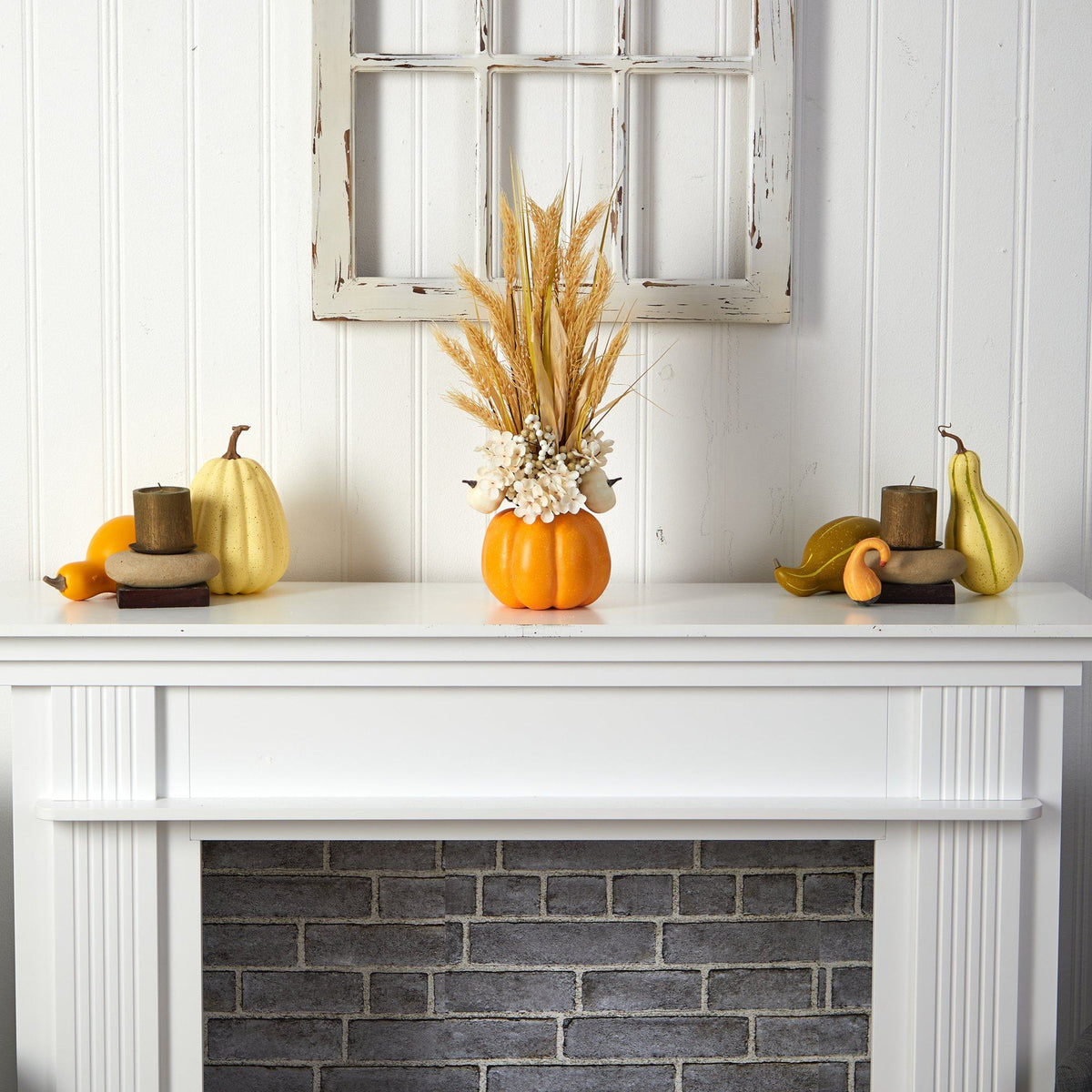 a white fireplace with a vase of wheat and pumpkins
