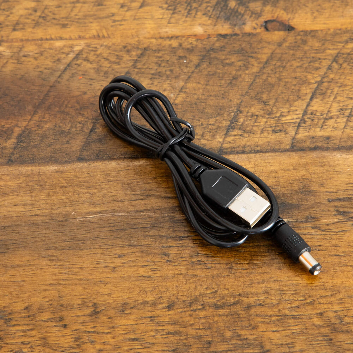 a black cord on a wooden surface