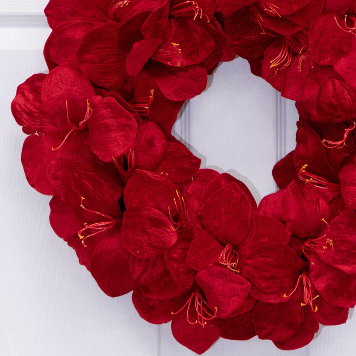 a red flower wreath on a white door