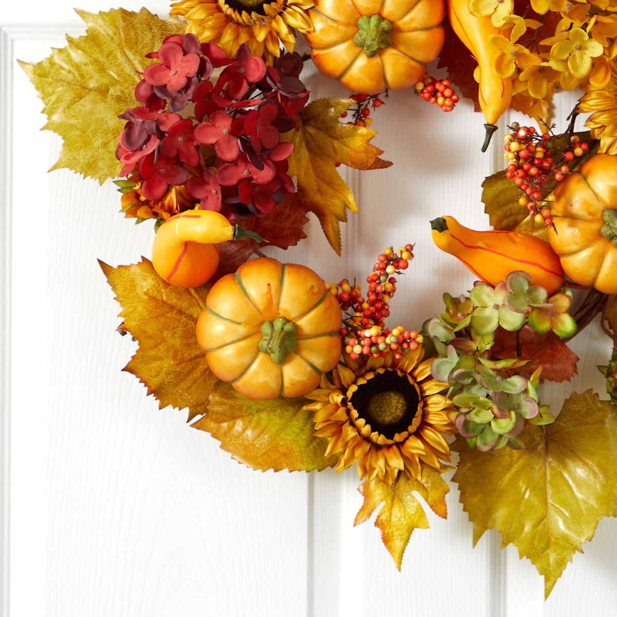 a wreath with flowers and pumpkins
