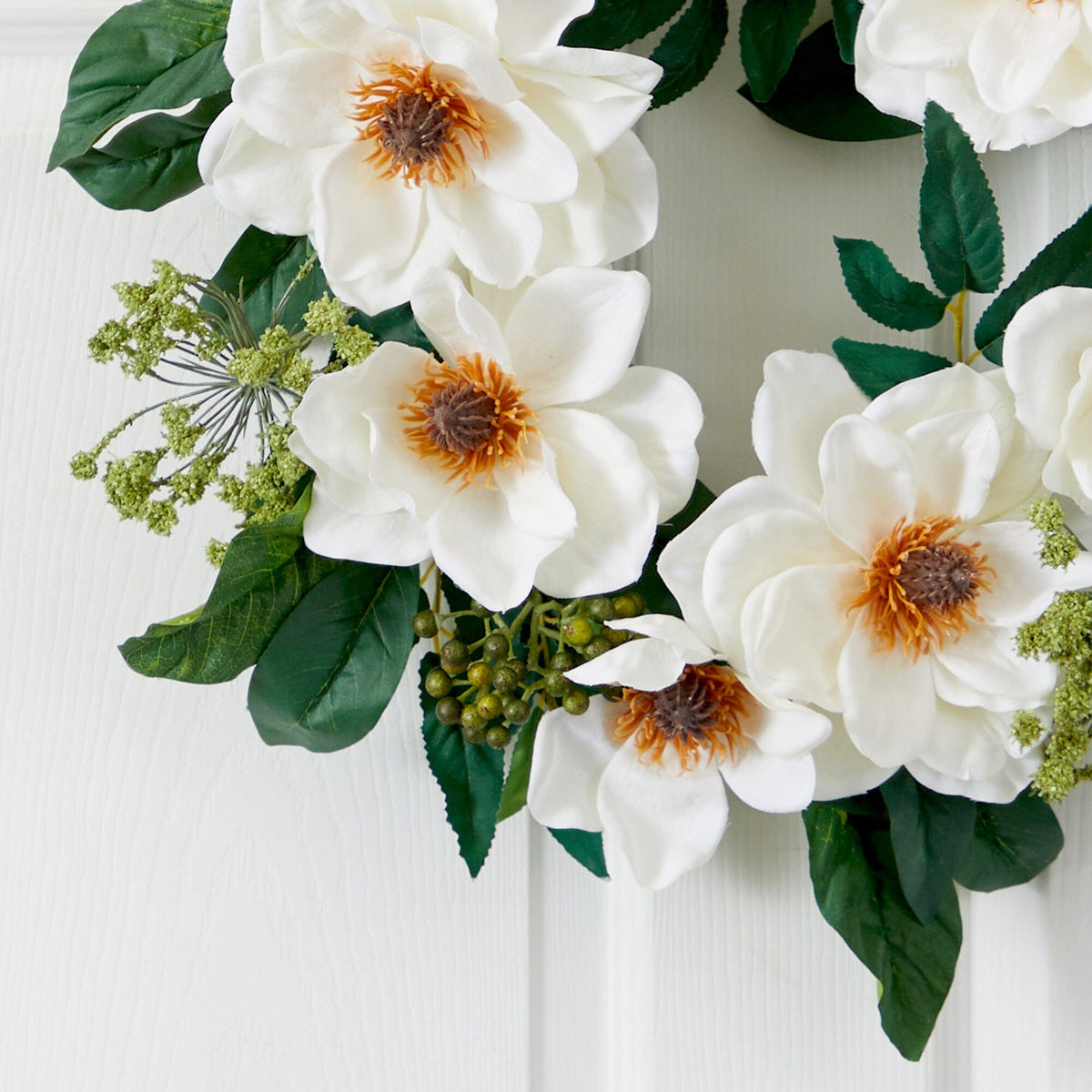 a wreath with white flowers and green leaves