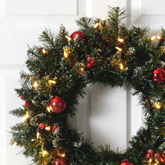 a wreath with lights and ornaments on it