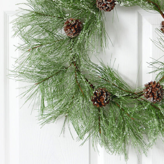 a wreath with pine cones and snow on it