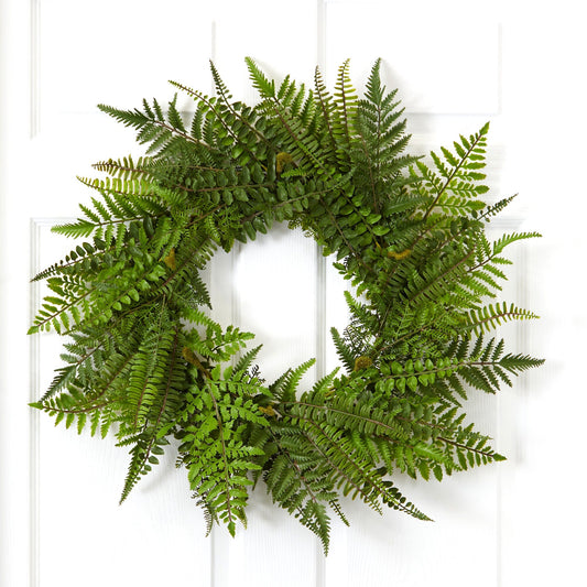 a green wreath on a white door