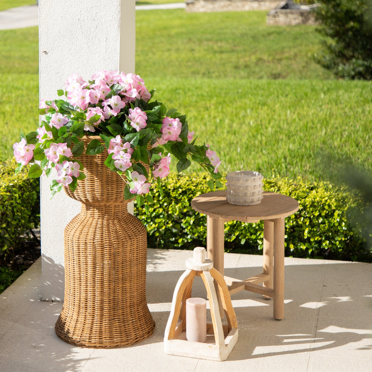 a vase with flowers and a candle on a patio