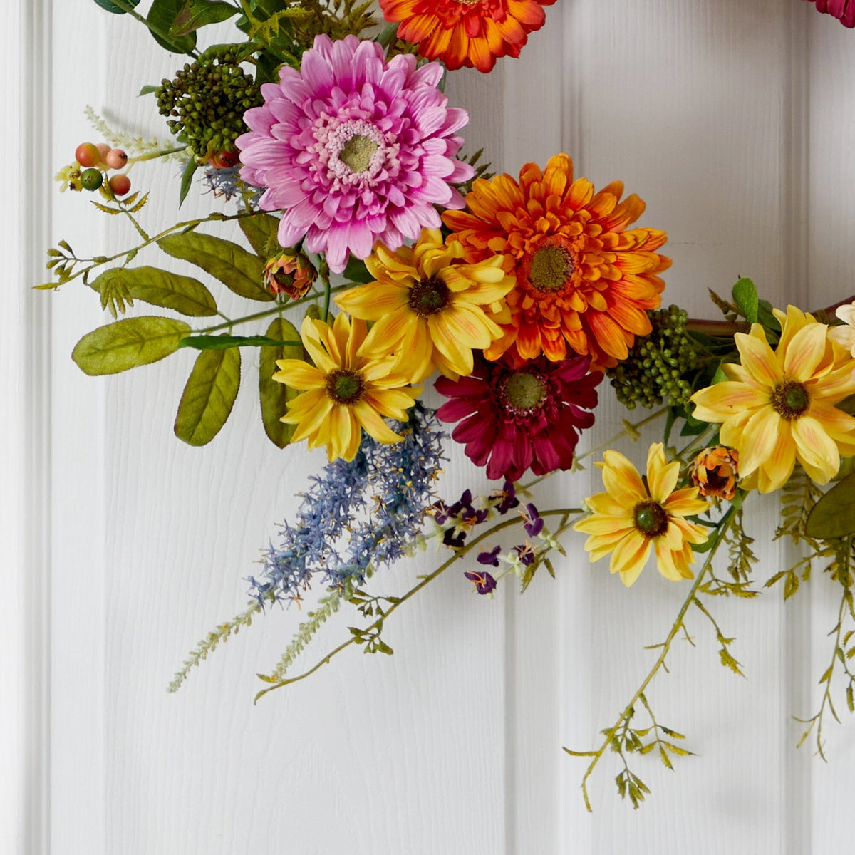 a wreath with flowers on a door
