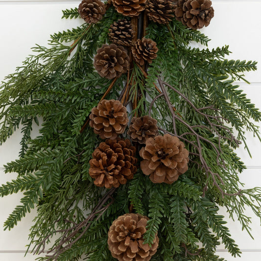 a pinecones and pine needles on a white wall