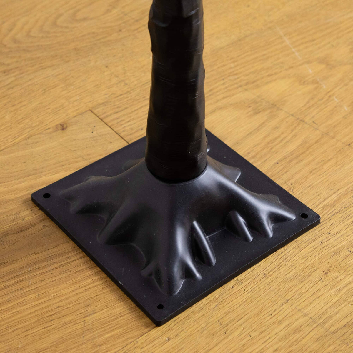 a black plastic base on a wood floor