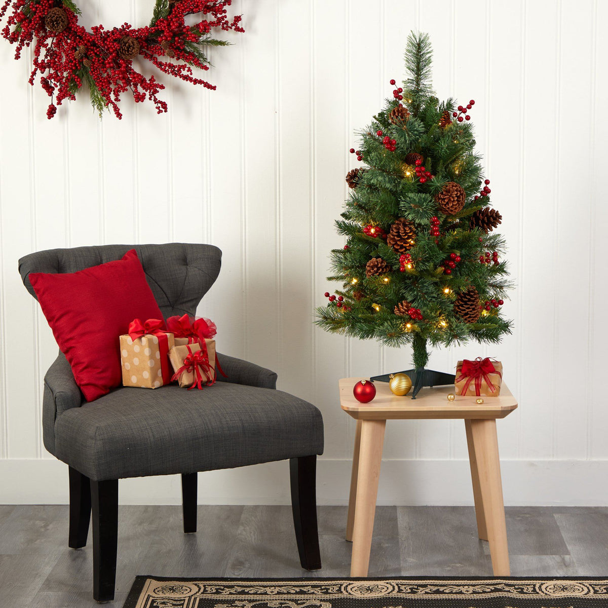 a christmas tree with presents and a chair