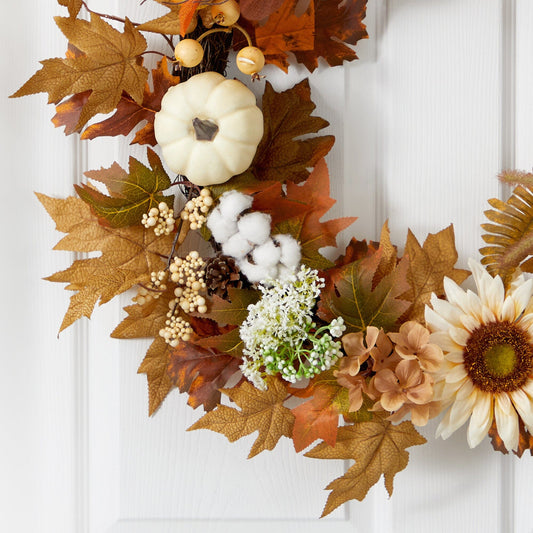 a wreath with flowers and leaves on a door