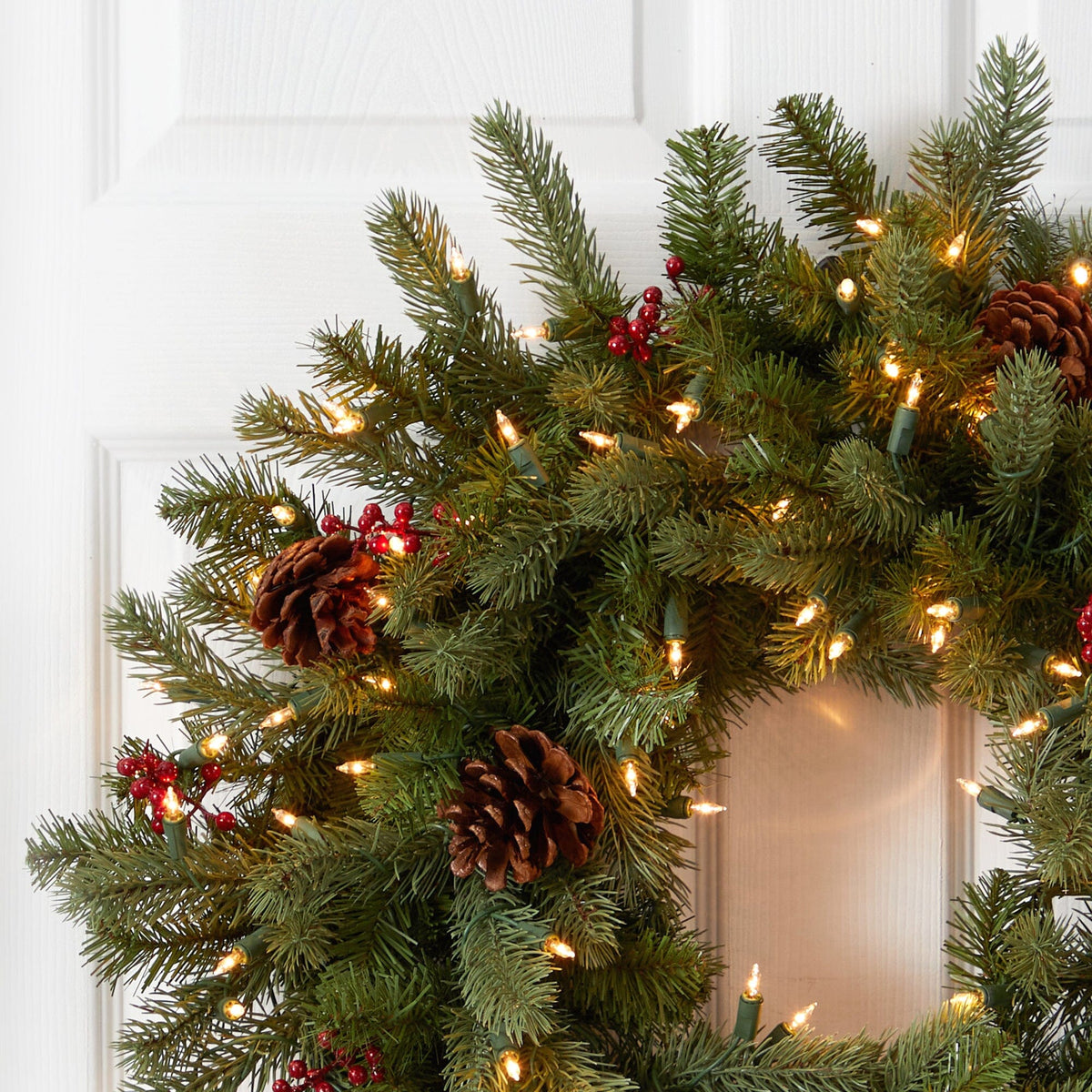 a wreath with lights and pine cones