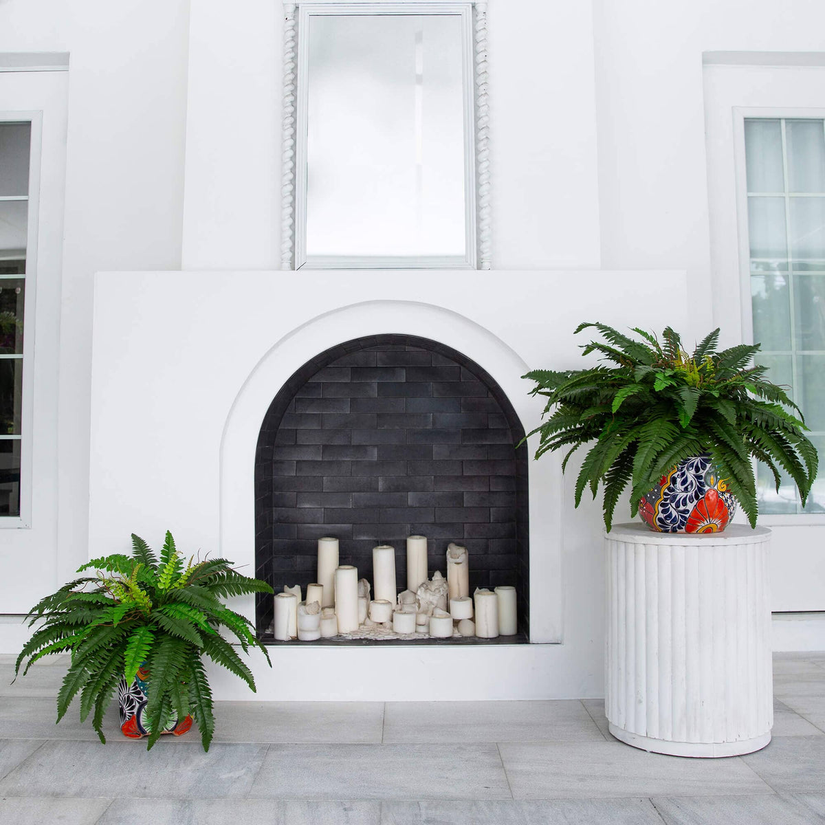 a fireplace with plants in front of a white building