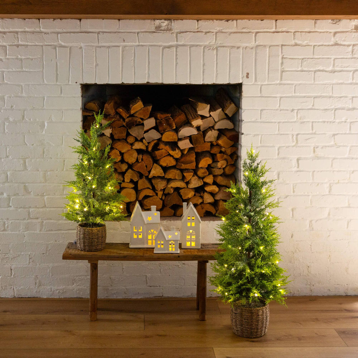 a woodpile with a fireplace and small trees